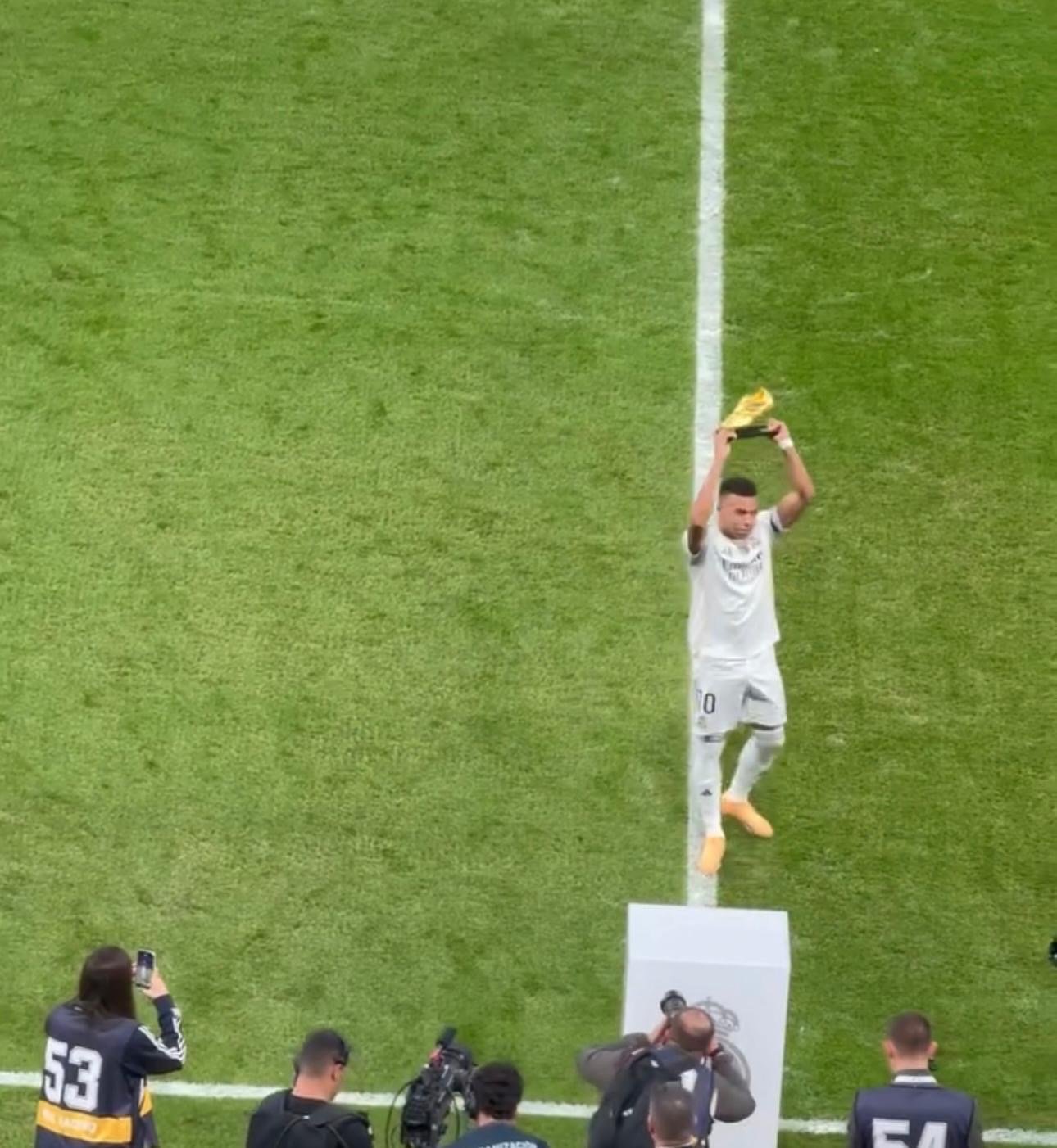 Kylian Mbappé lifts the Golden Boot trophy triumphantly.